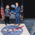 Executive Mosaic’s Jim Garrettson Delivers Booz Allen Hamilton’s Judi Dotson 2023 Wash100 Award