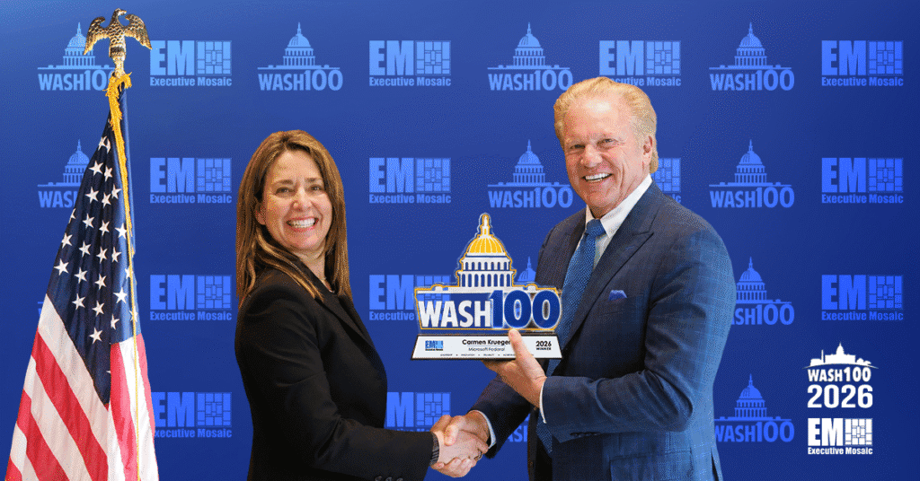 Carmen Krueger and Jim Garrettson. The Microsoft corporate VP of U.S. federal shook hands with Garrettson as she accepted her 2026 Wash100 Award.