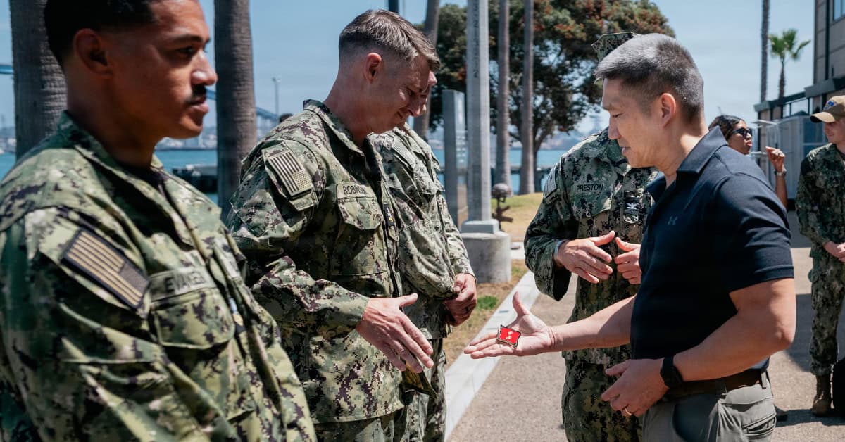 Hung Cao, acting Navy secretary (right), presents a coin to an explosive ordnance disposal technician on Aug. 6, 2026. Photo: USN Hung Cao. The acting Navy secretary (right), presents a coin to an explosive ordnance disposal technician on Aug. 6, 2026